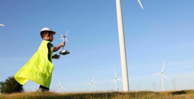 Child holding wind turbine in front of wind turbines